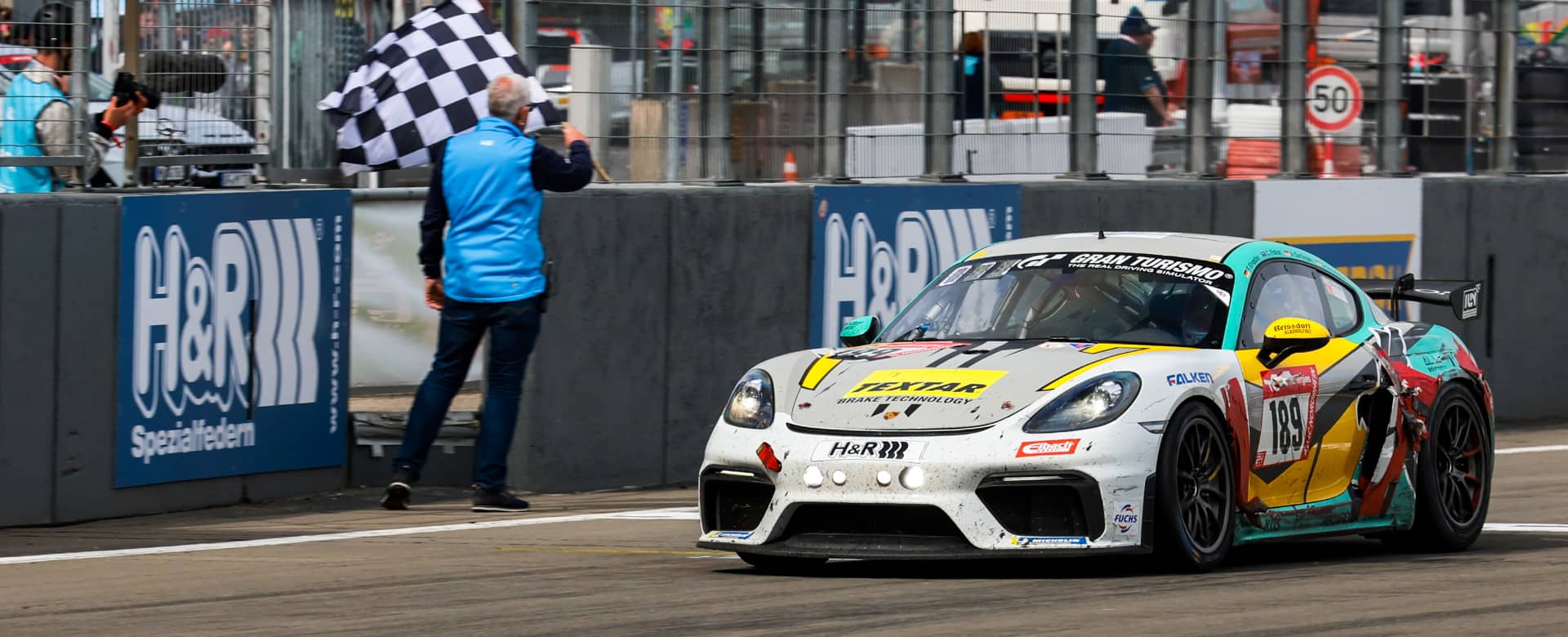 BLACK FALCON Team TEXTAR Porsche Cayman GT4 bei der Zieldurchfahrt Nürburgring 24h-Rennen 2023